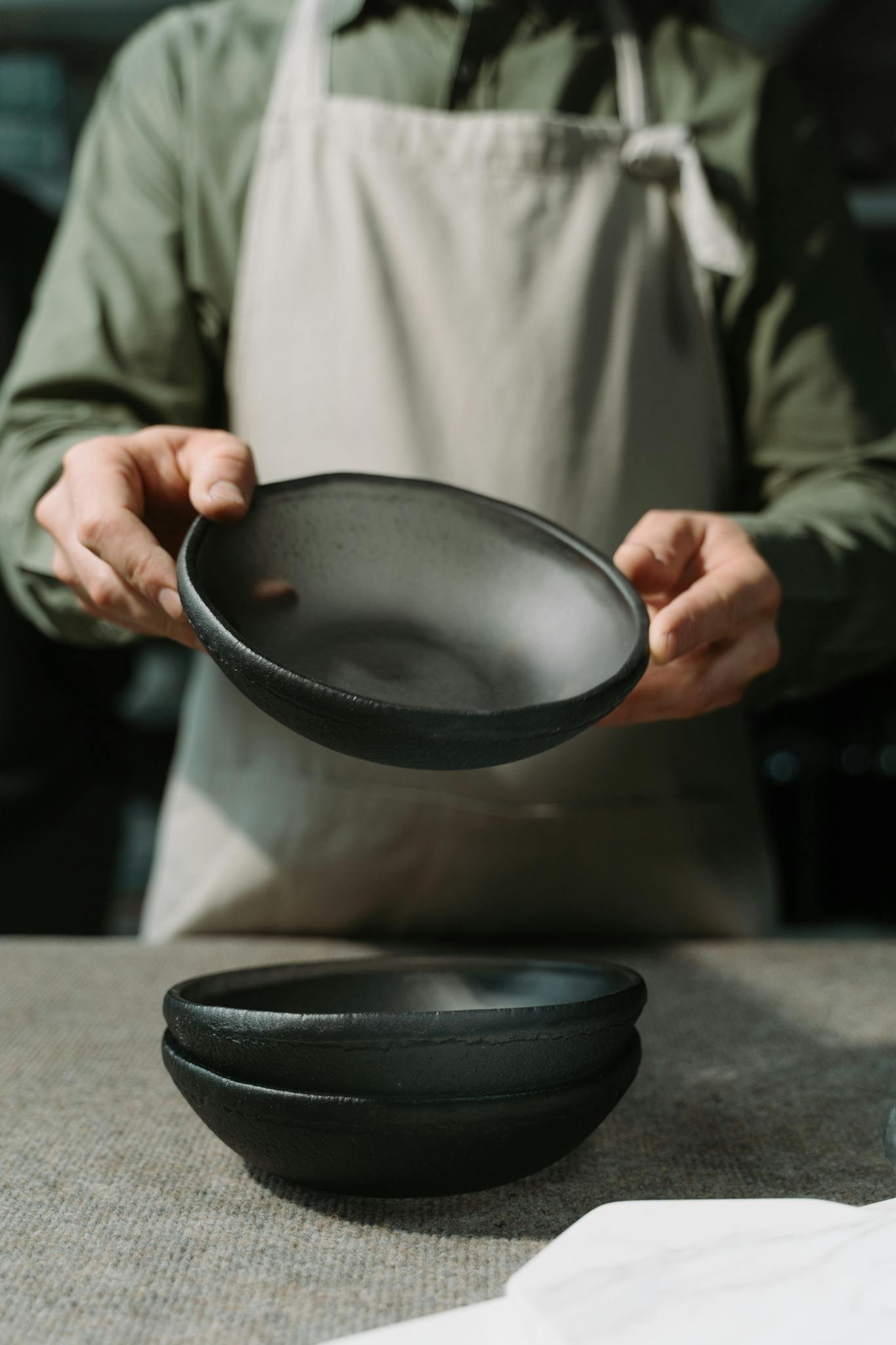 Close-up of artisan holding handmade ceramic bowls showcasing craftsmanship.